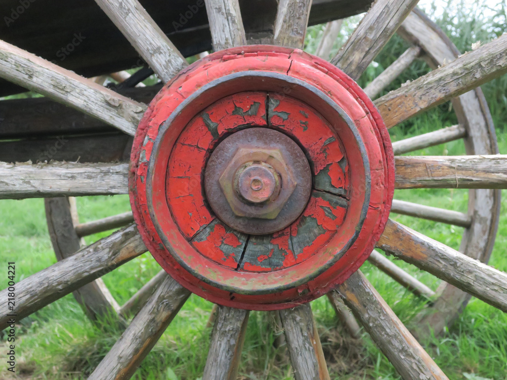red painted wooden wheel axle with bolt + nut of an old car detail red painted wooden wheel axle with bolt + nut of an old car detail