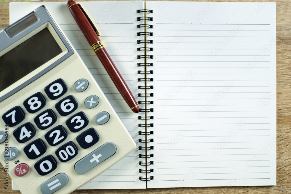Fountain pen or ink pen with notebook paper and calculator on wooden working table with copy space, office desk concept. top view.. Fountain pen or ink pen with notebook paper and calculator on wooden working table with copy space, office desk concept. top view..