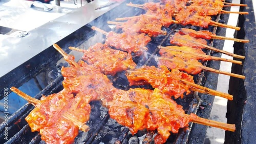 Chicken tied up with bamboo stick grilled on chacoal stove. photo