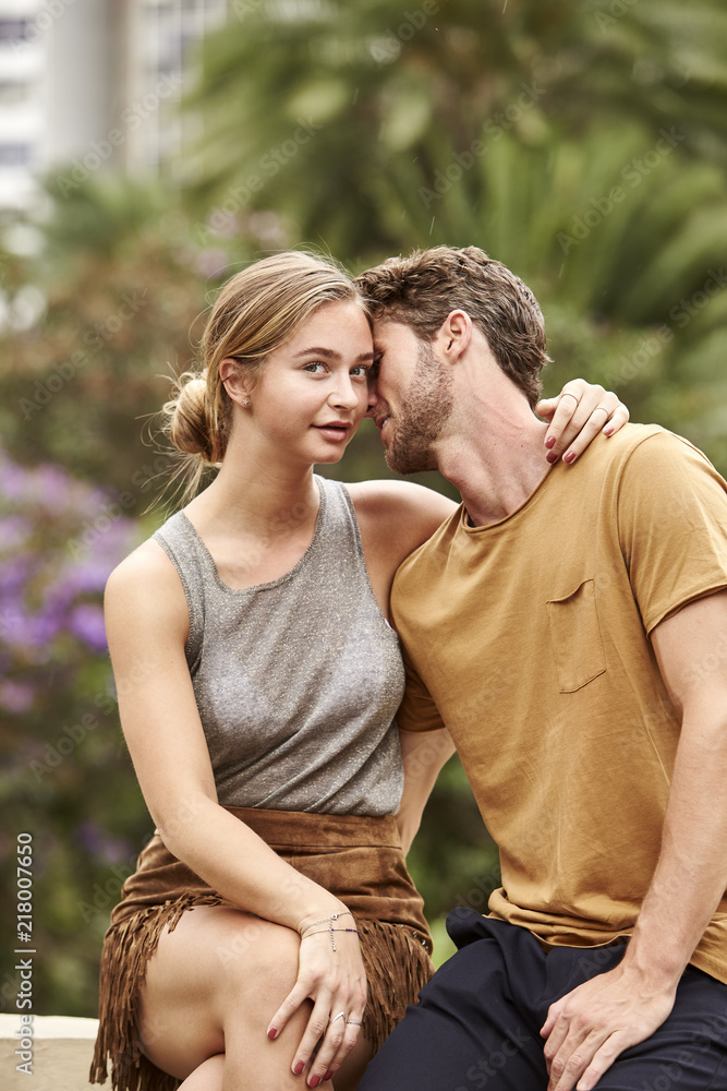 Obraz premium Beautiful girl sitting with boyfriend