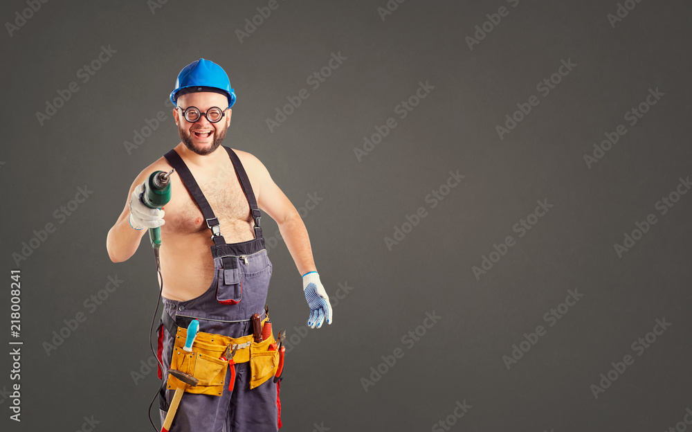 The fat funny man builder with a drill on a background for text.