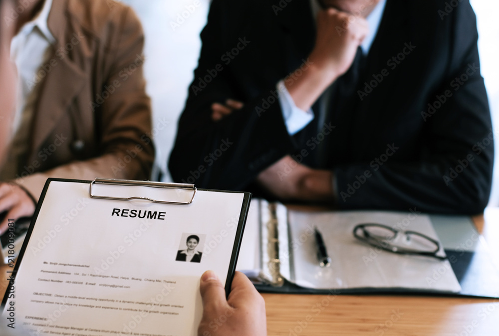 Examiner reading a resume during job interview at office Business and human resources concept Examiner reading a resume during job interview at office Business and human resources concept