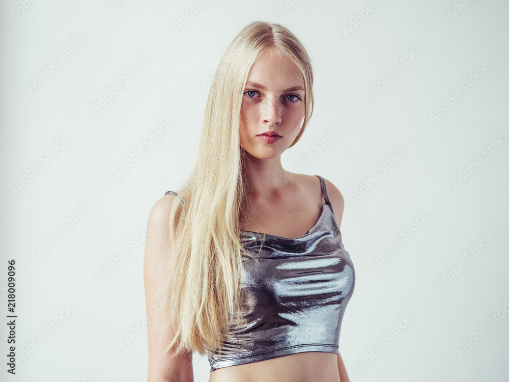 Blonde long hair woman girl in silver dress over white background Blonde long hair woman girl in silver dress over white background