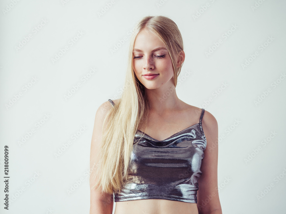 Naklejka premium Blonde long hair woman girl in silver dress over white background