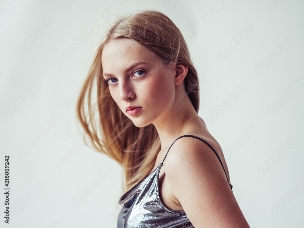 Blonde long hair woman girl in silver dress over white background Blonde long hair woman girl in silver dress over white background