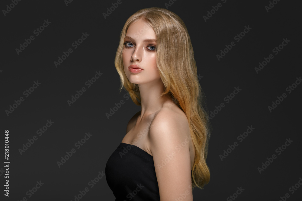 Beautiful woman with long blonde hair over gray background beauty female