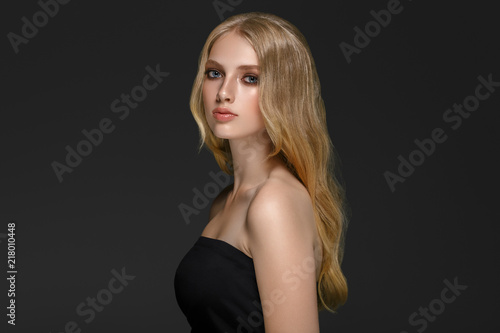Beautiful woman with long blonde hair over gray background beauty female
