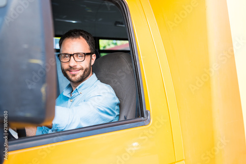 handsome happy school bus driver looking at camera
