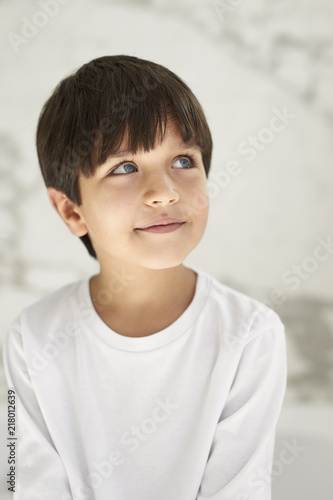Thoughtful boy in white looking up