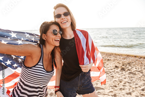 Friends outdoors on the beach holding USA flag having fun.