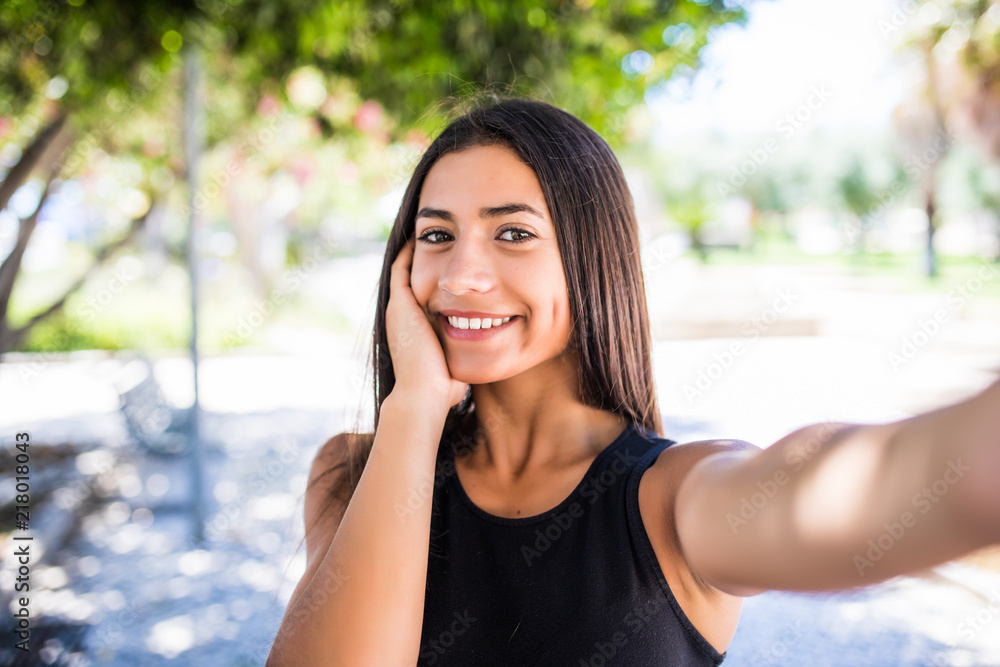 Portrait of pretty young latin girl taking selfies with her smart phone in the street Portrait of pretty young latin girl taking selfies with her smart phone in the street