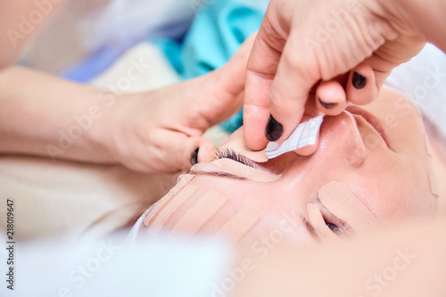 Kinesiotaping. Young woman lying with tape on her face. Physiotherapy and cosmetology procedure. Method of non-surgical skin rejuvenation. Facial skin care