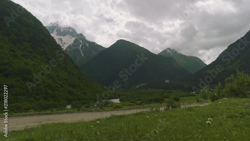 River and roadleading to great severe Ossetian mountains photo