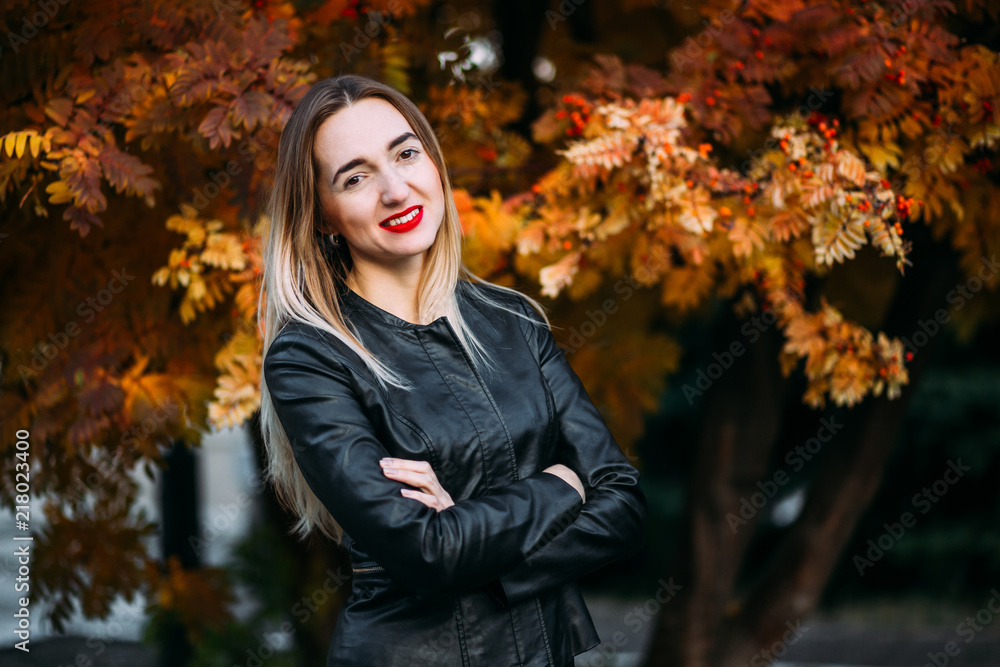 young woman in a black leather jacket looks into the camera young woman in a black leather jacket looks into the camera