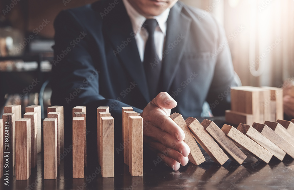 Φωτογραφία Business risk control concept, Businessman protect wooden block fall to planning and strategy in risk to business Alternative and prevent