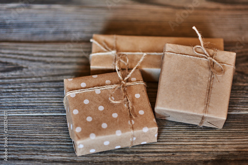 Handmade gift boxes wrapped with eco friendly craft paper and tied with twine on wooden vintage background. Background for your design. Holiday packing concept. Copy space for text. .