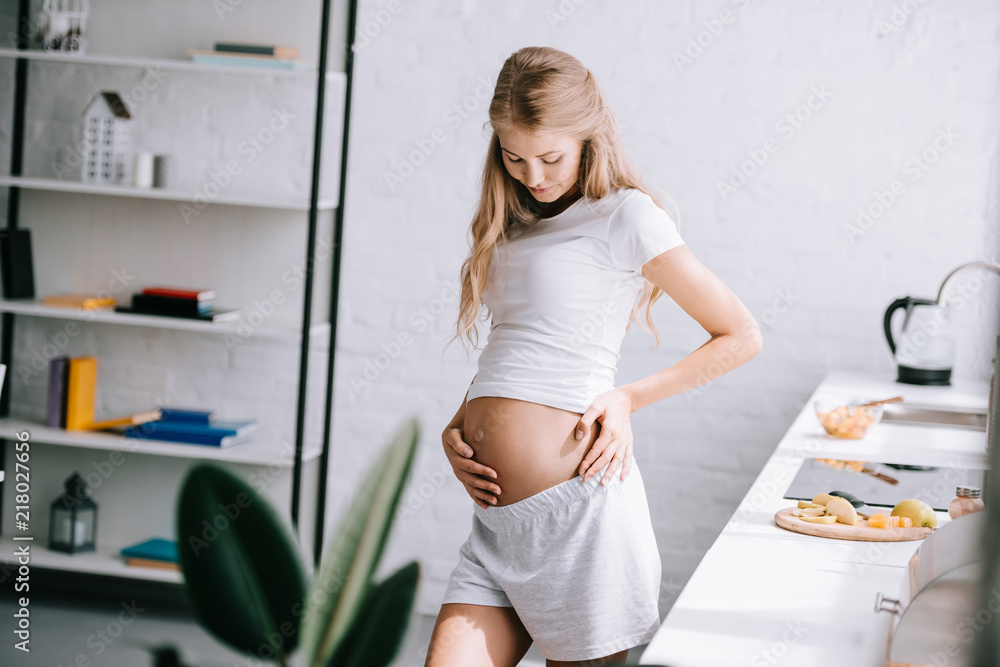 beautiful pregnant woman with hands in belly standing at home beautiful pregnant woman with hands in belly standing at home