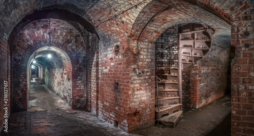 Kaliningrad  Russia - May  2018. Brick underground corridor and light in end spiral staircase. Panoramic view.