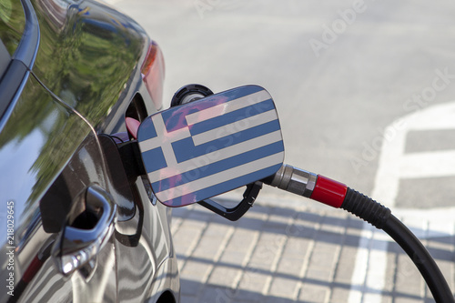 Fueling car with petrol pump at a gas station.
