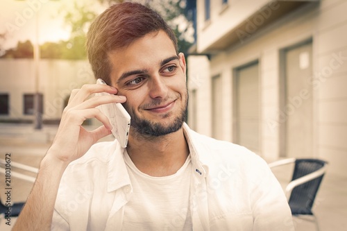 young man smiling with outdoor mobile phone