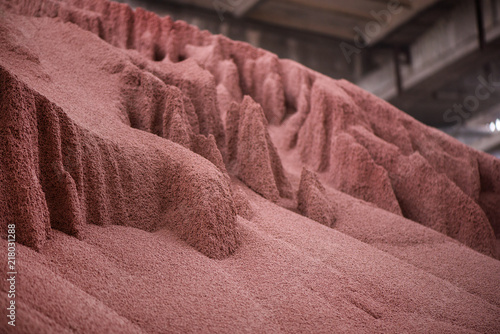 Shot of mixed chemical, artificial nitrogen plant fertilizer granules in factory. Big heaps of mineral pellets creating abstract textures, patterns. Minerals used in agriculture, farms, fields photo