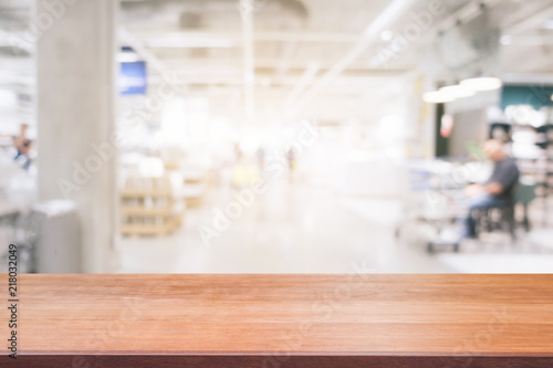 Wooden board empty table blurred shopping mall background. Perspective brown wooden table blur in department store background - can be used for display or montage your products. Mock up for of product