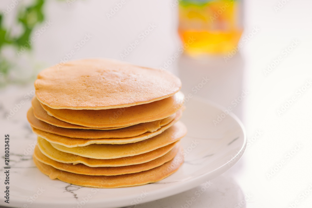 Stack of delicious pancakes on plate isolated on white