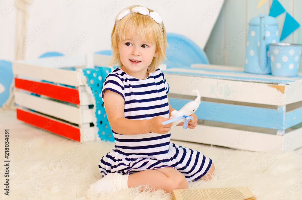 blond girl sitting on the floor with a toy blond girl sitting on the floor with a toy