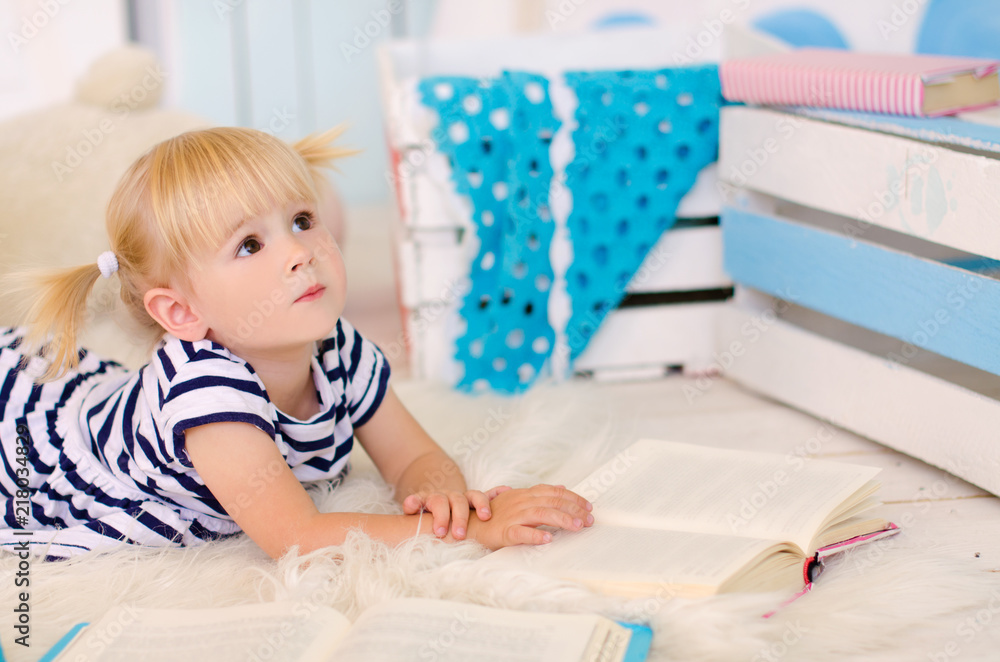 blond girl lying on the floor with books blond girl lying on the floor with books