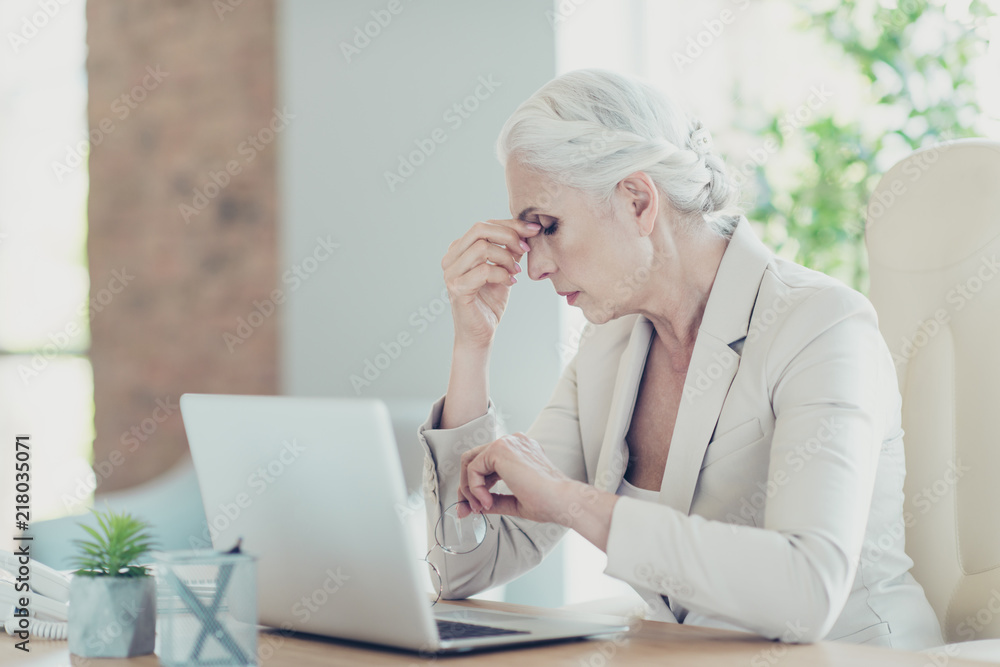 Gray-haired beautiful stylish old unhappy lady sitting in front 