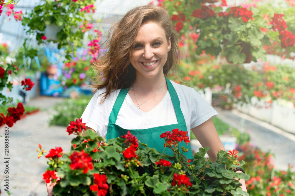 Beautiful young florist holding flowers
