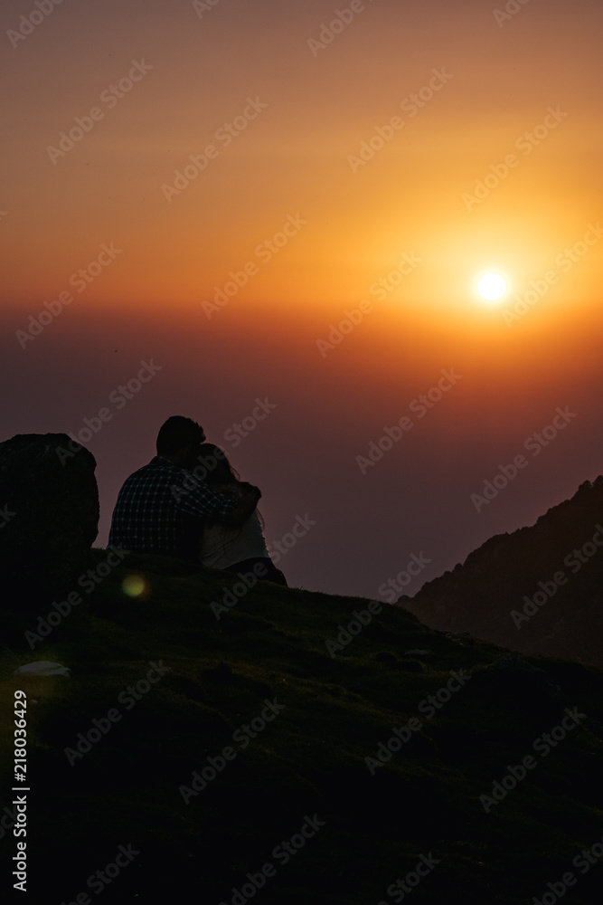 A couple who watching sunset on the mountain