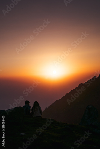 A couple who watching sunset on the mountain