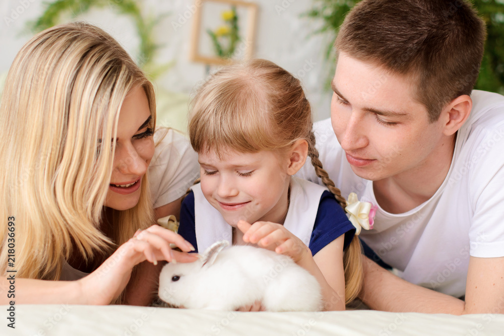 family playing with white rabbit family playing with white rabbit