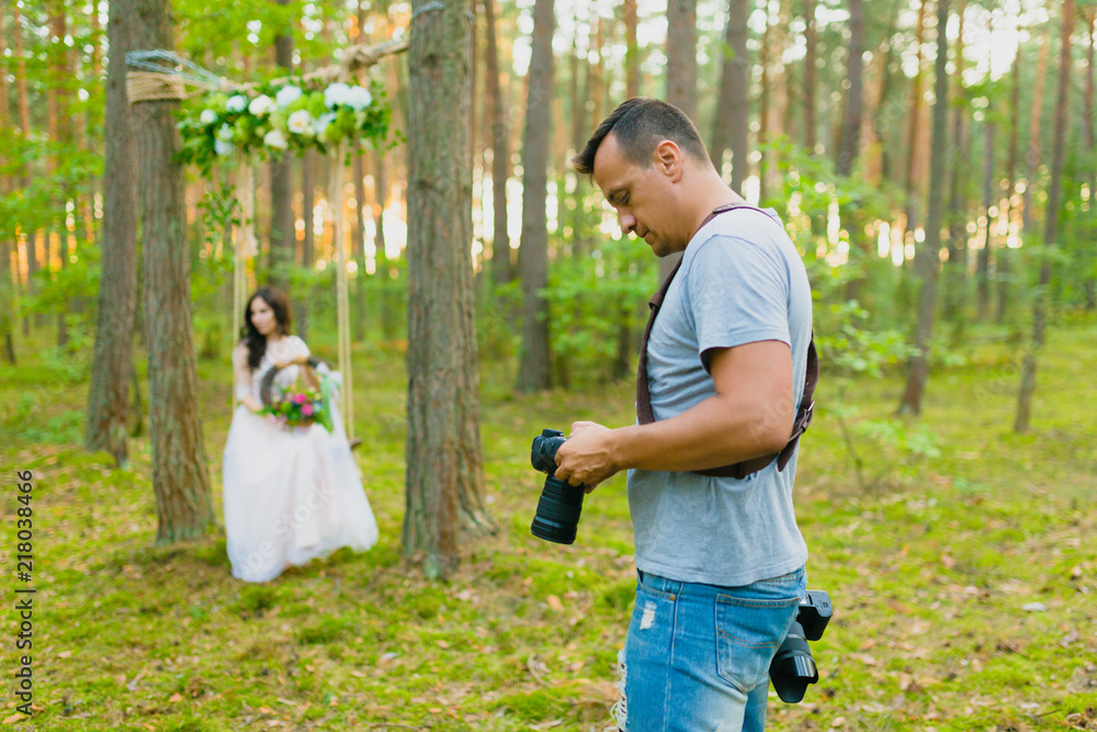 Photographer taking pictures of the bride on a rope swing Photographer taking pictures of the bride on a rope swing