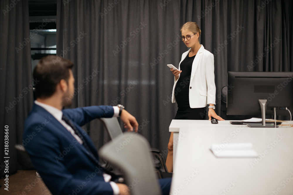 Fototapeta premium selective focus of businesswoman with smartphone and colleague at workplace in office