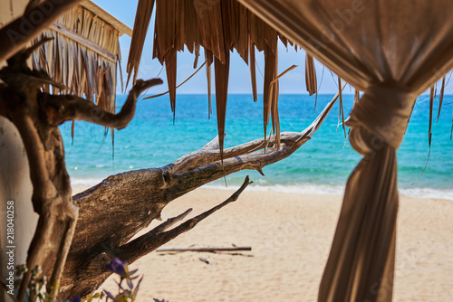 Panoramic view through  terrace bar made of weathered wood near tropical coastline. Azure water of ocean on the background. © eskstock