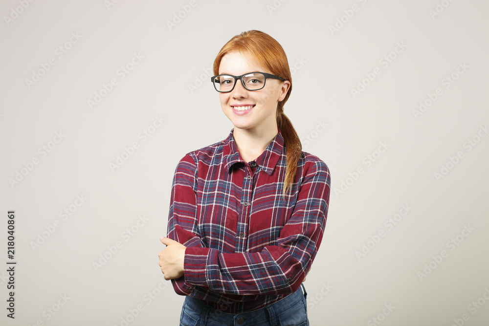 Beautiful young woman wearing flannel shirt & black frame eyeglasses standing in confident pose with folded hands. Female college student with crossed arms. Background, copy space, close up portrait.