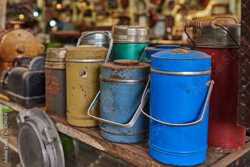 Many used thermos bottle. Retro equipment. Various objects for sale at a indoor flea market. View of a display full of interesting old things for sale. Vintage assorted second-hand objects. © eskstock