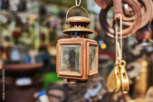 Vintage lamps. Various vintage objects for sale at a indoor flea market. View of a display full of interesting old things for sale. Many groups of vintage assorted second-hand objects. photo