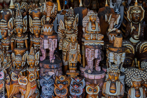 Typical souvenir shop selling souvenirs and handicrafts of Bali at the famous Ubud Market, Indonesia. Balinese market. Souvenirs of wood and crafts of local residents. Wooden statues made from wood.