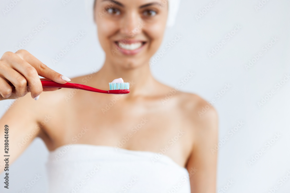 Smiling happy young woman with healthy teeth holding a tooth brush. Clean beauty and healthy concept Smiling happy young woman with healthy teeth holding a tooth brush. Clean beauty and healthy concept
