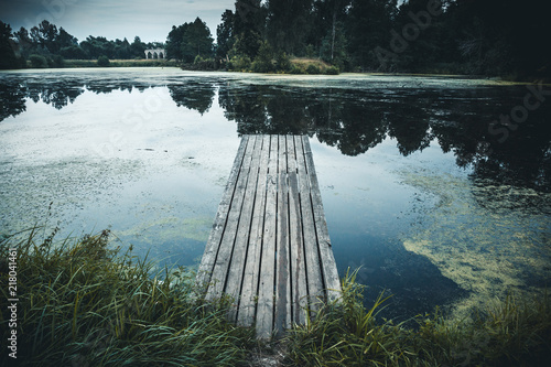 Old wooden pier in lake, Idyllic tranquil view nature background with reflection in water