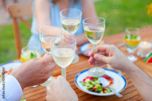 Family outdoor dinner in the garden in summer at sunset. Picnic food and drink concept