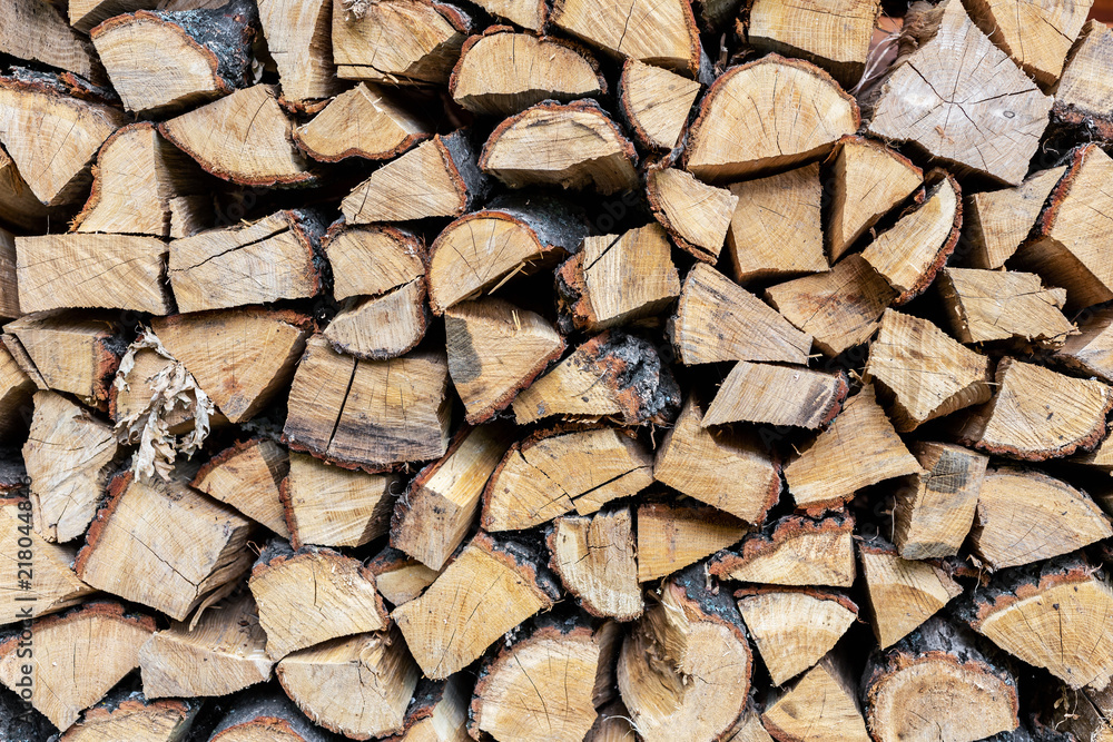 Firewood stack wall. Stack of wood prepared for winter and cold weather. Dry chopped oak wood. Wooden background texture Firewood stack wall. Stack of wood prepared for winter and cold weather. Dry chopped oak wood. Wooden background texture
