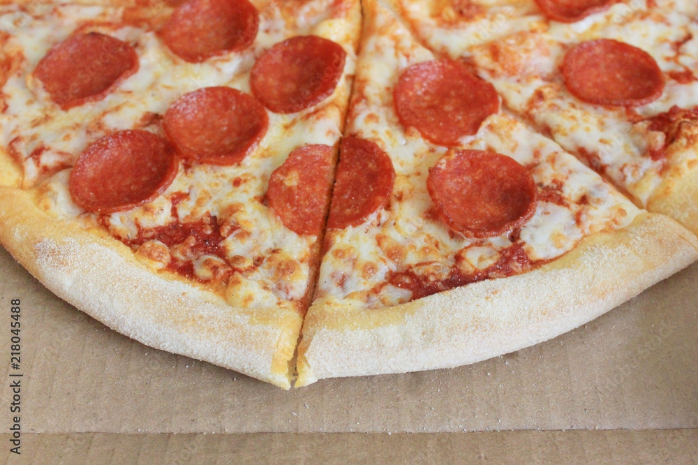 Pepperoni Pizza Slices in Take Away Delivery Box Close Up Top View. Pepperoni Traditional Italian Recipe Pizza with Pepperoni Sasauge, Melted Cheese and Tomato Sauce Sliced in Delivery Box Pepperoni Pizza Slices in Take Away Delivery Box Close Up Top View. Pepperoni Traditional Italian Recipe Pizza with Pepperoni Sasauge, Melted Cheese and Tomato Sauce Sliced in Delivery Box