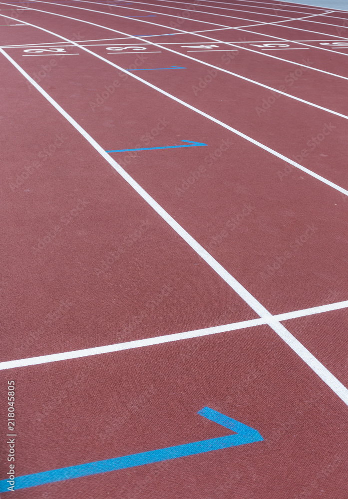 Red sport track for running on stadium starting marks. Running healthy lifestyle concept. Sports background abstract texture