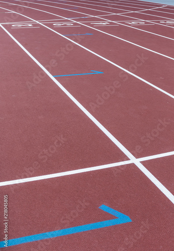 Red sport track for running on stadium starting marks. Running healthy lifestyle concept. Sports background abstract texture