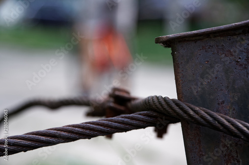 Thick steel rope close up. Bridge fence element. Detailed view. The surface of the steel cable is covered with rust.