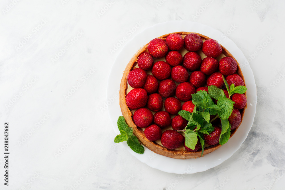 Cheesecake with fresh strawberries and mint on white plate on gray concrete background. Top view. Cheesecake with fresh strawberries and mint on white plate on gray concrete background. Top view.